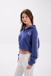 Woman wearing a blue hoodie with a logo on a white background.