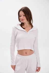 Woman wearing a light gray hoodie and pants on a white background.