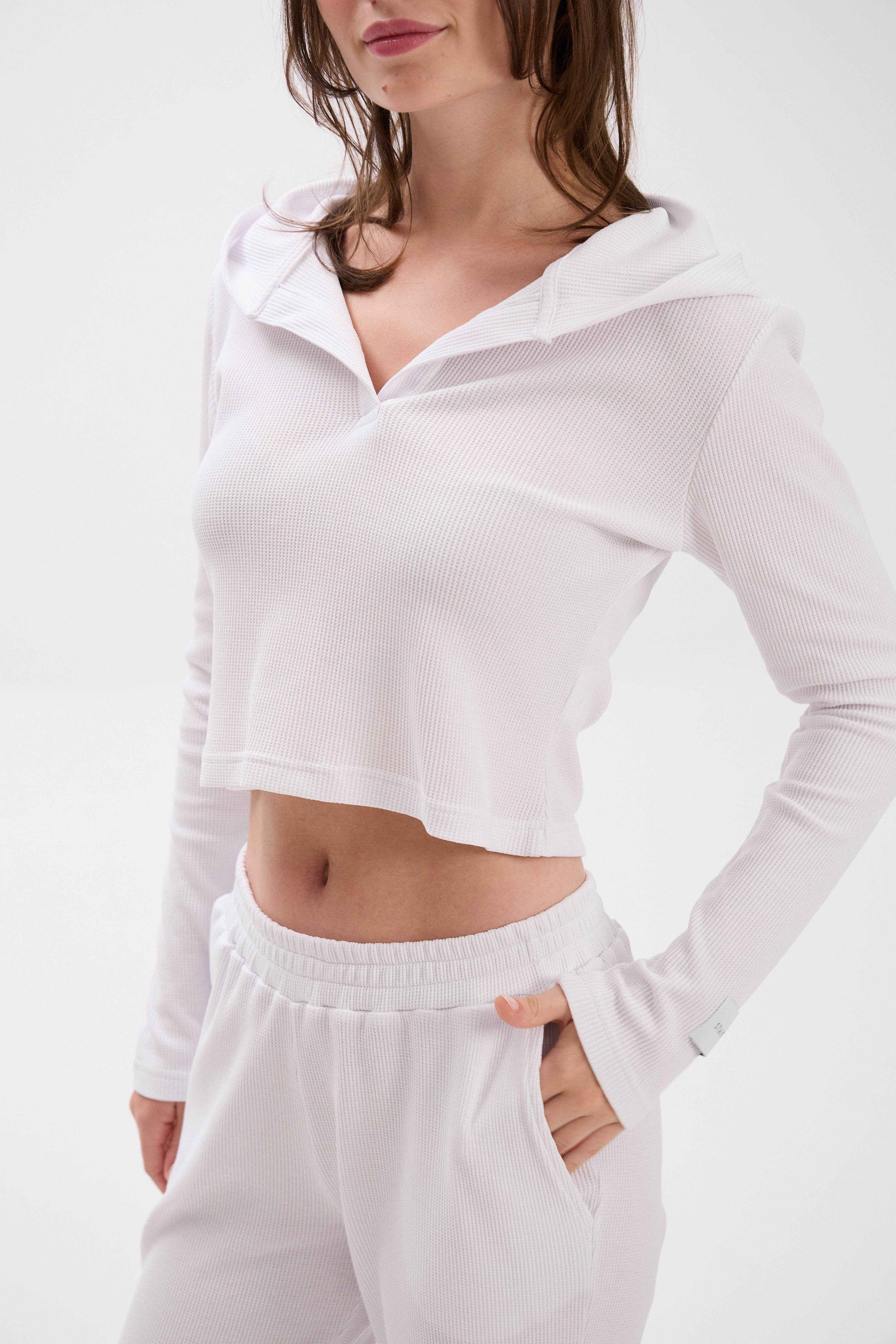 White long-sleeve crop top and pants on a plain background.