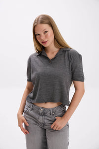 Woman wearing a gray polo shirt and jeans on a white background