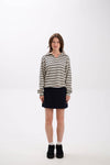 Woman wearing a striped shirt and black skirt on a white background