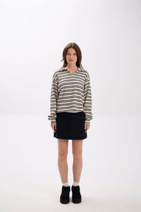 Woman wearing a striped shirt and black skirt on a white background