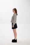 Woman wearing a striped shirt and black skirt on a white background