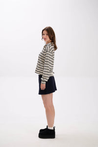 Woman wearing a striped shirt and black skirt on a white background