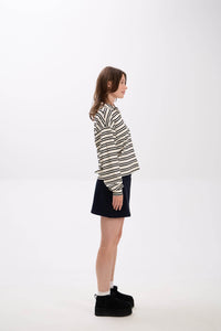 Person wearing a striped shirt and black skirt on a white background