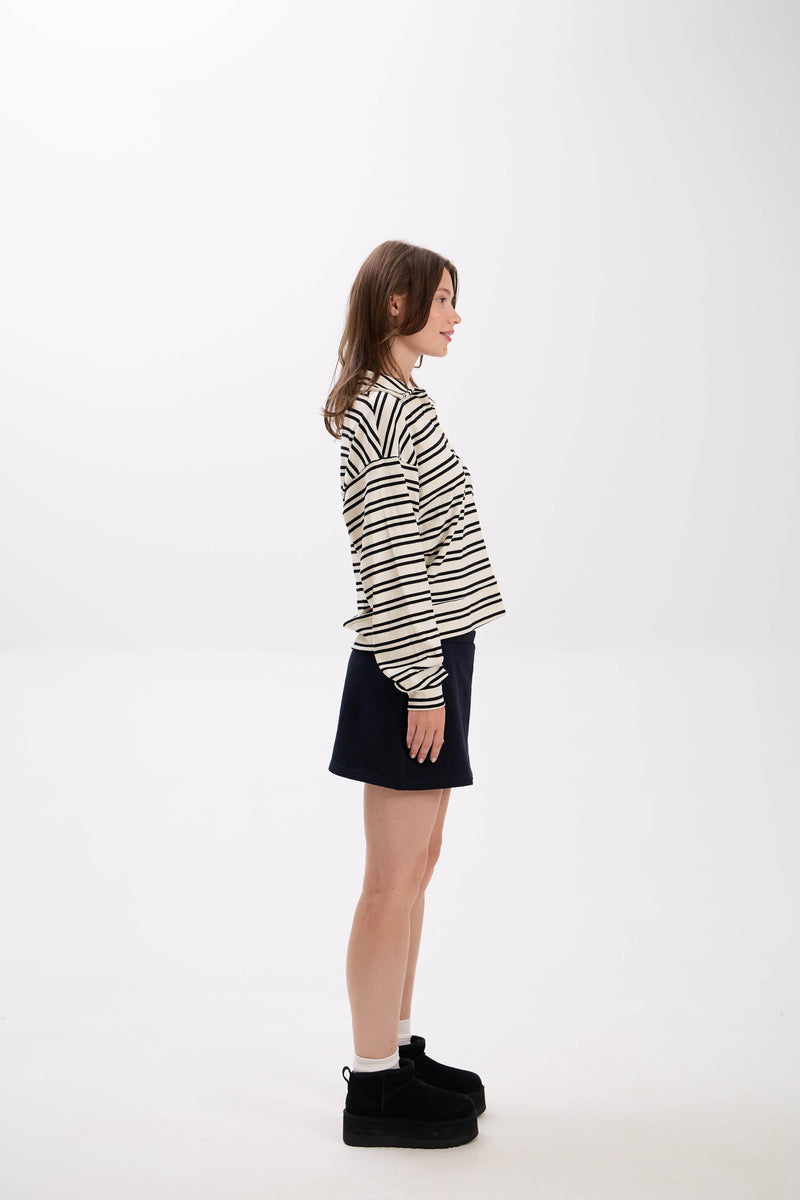 Person wearing a striped shirt and black skirt on a white background