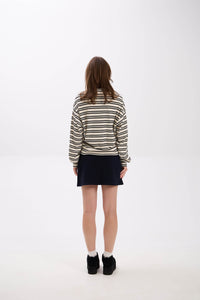 Person wearing a striped sweater and black skirt on a white background
