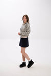 Woman wearing a striped sweater, black skirt, and black boots on a white background