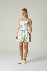 Woman wearing a floral dress on a plain background.