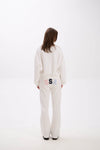 Person wearing a white outfit with a logo on a white background.