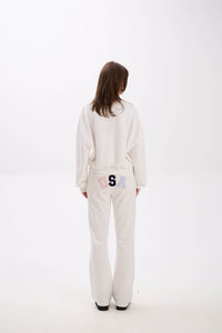 Person wearing a white outfit with a logo on a white background.