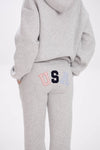 Grey hoodie and sweatpants with elastic waistband, side pockets, and multicolor USA lettering on the back.