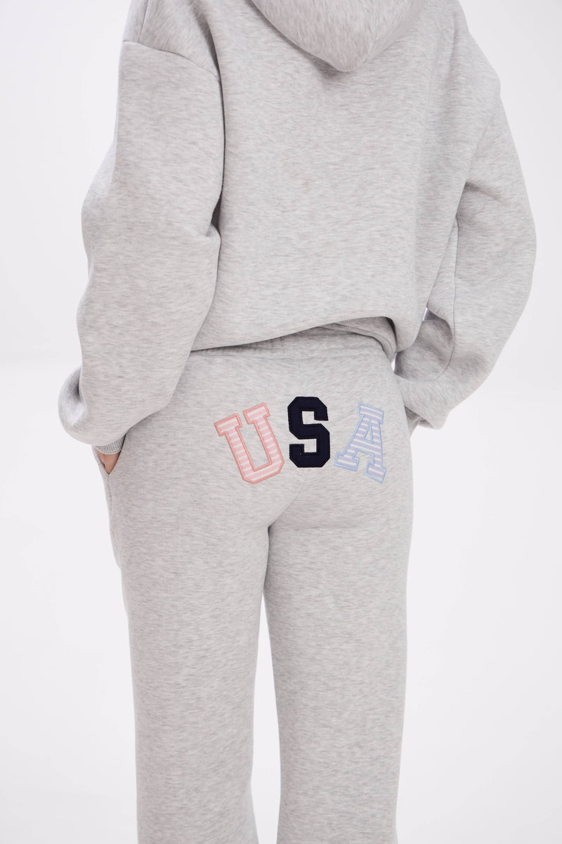 Grey hoodie and sweatpants with elastic waistband, side pockets, and multicolor USA lettering on the back.