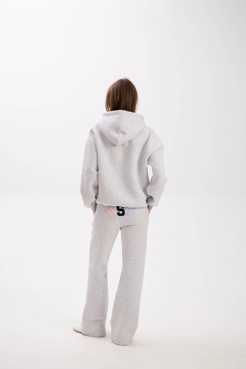 Grey hoodie and sweatpants with elastic waistband, side pockets, and multicolor USA lettering on the back.