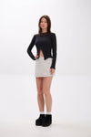 Woman wearing a black top and Grey Melange / Grey skirt on a white background
