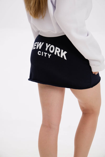 Person wearing a navy/black skirt with 'New York City' text on a white background
