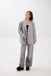 Woman wearing a gray suit on a white background.
