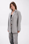 Woman wearing a gray suit on a white background.