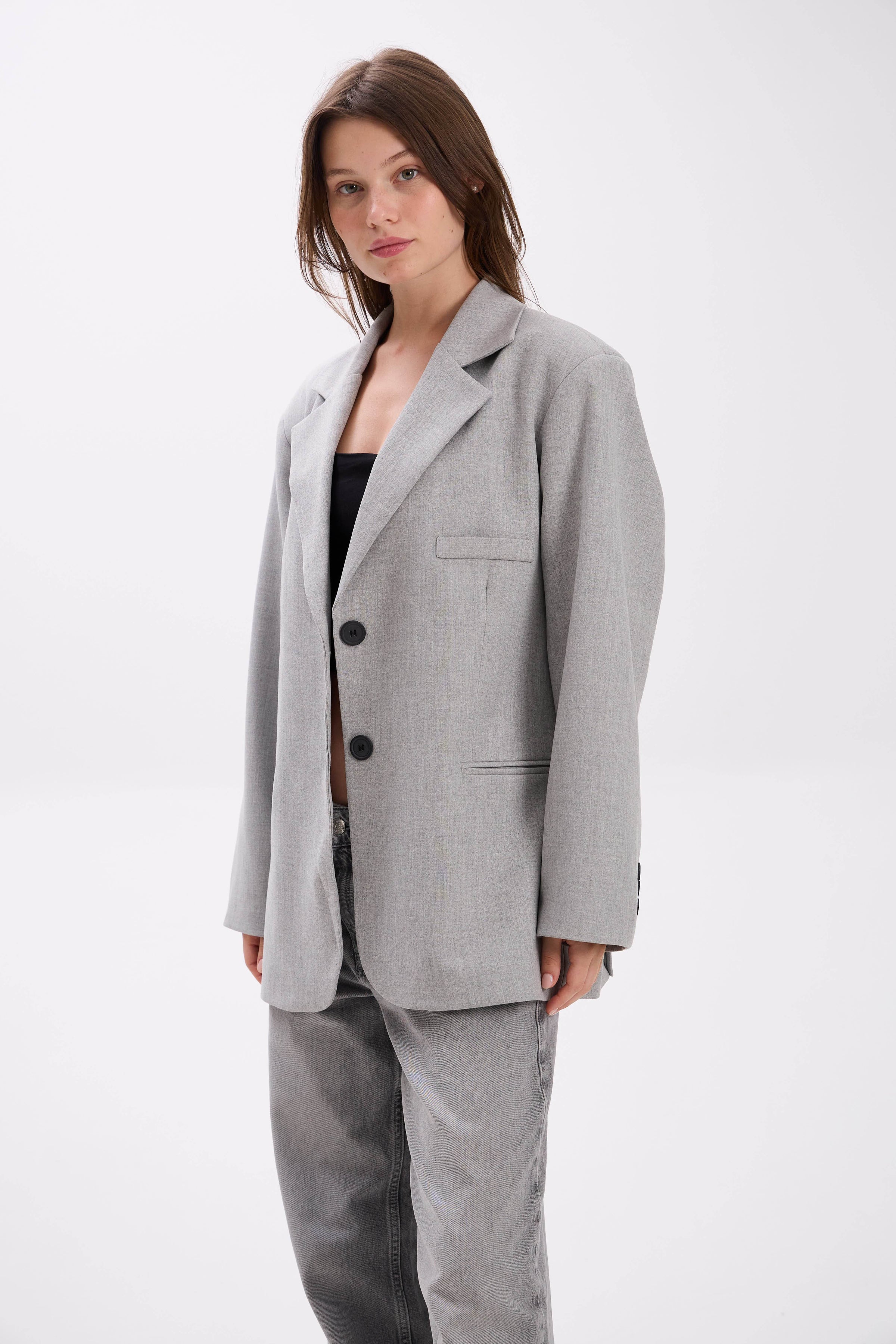 Woman wearing a gray suit on a white background.