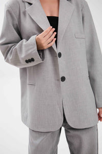 Gray suit jacket with black buttons on a white background.