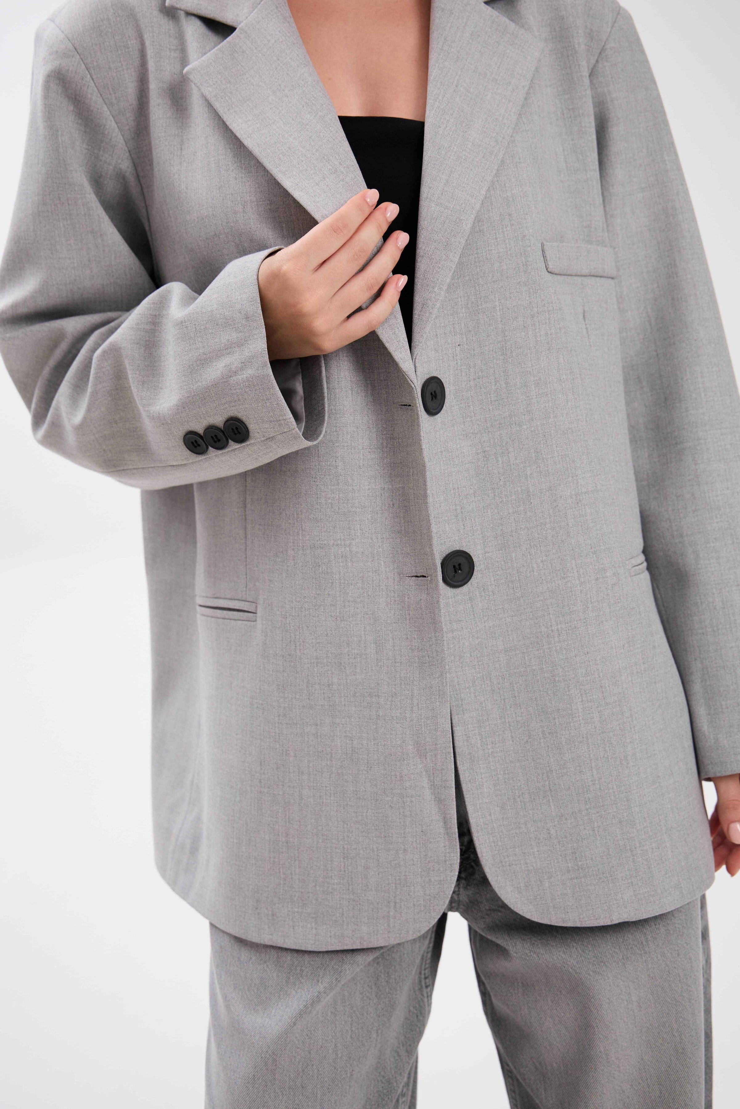Gray suit jacket with black buttons on a white background.
