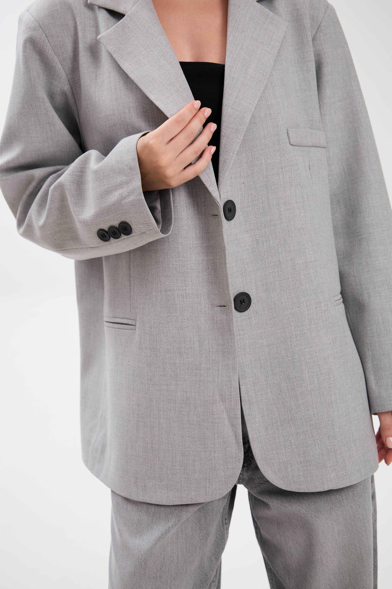 Gray suit jacket with black buttons on a white background.