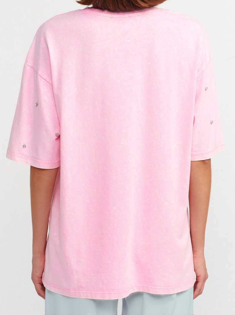 Person wearing a pink oversized t-shirt on a white background.