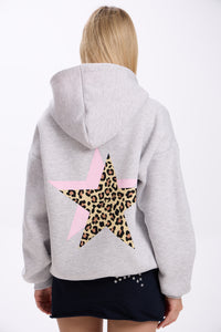 Person wearing a gray hoodie with a leopard print star on the back against a white background