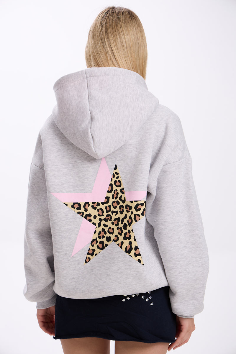 Person wearing a gray hoodie with a leopard print star on the back against a white background