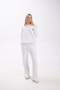 Woman wearing a white outfit with a star detail on a white background