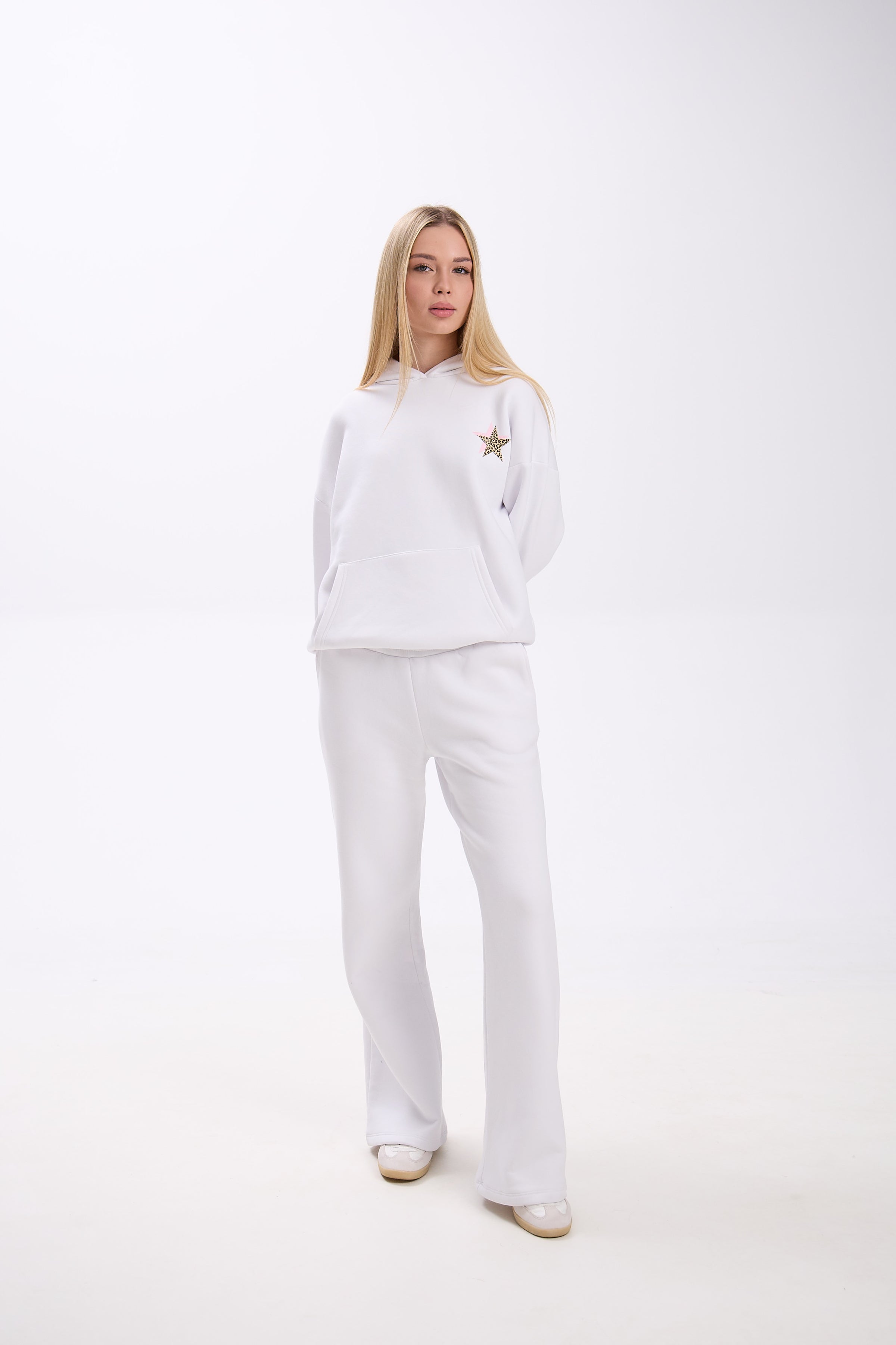Woman wearing a white outfit with a star detail on a white background