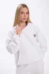 Woman wearing a white sweatshirt with a star design on a white background