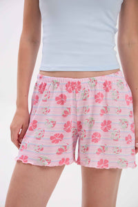 Person wearing a light blue crop top and pink floral shorts on a white .background