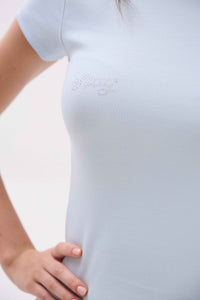 Light blue dress with lace details on a blurred background.