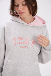 Person wearing a gray hoodie with pink interior and 'Stay Close' text on a white background.