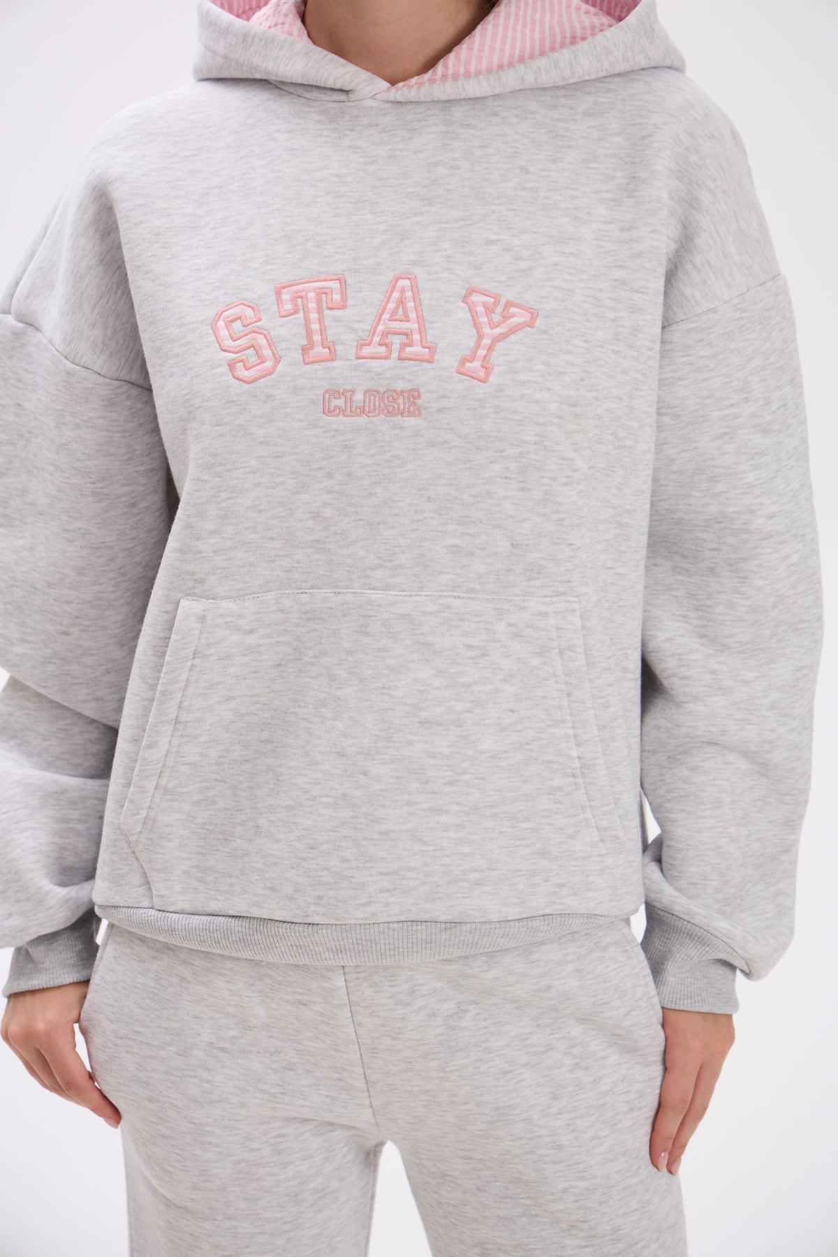 Gray hoodie with pink text on a white background.