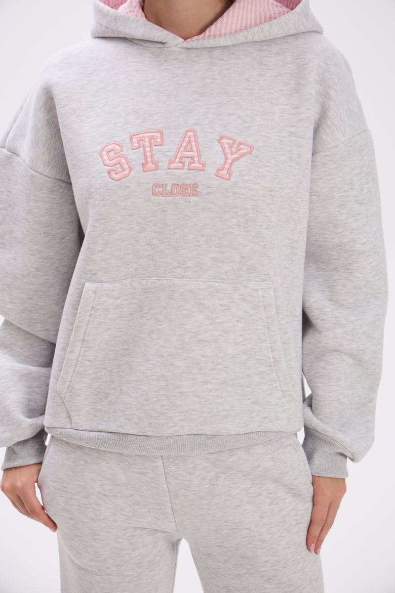 Gray hoodie with pink text on a white background.