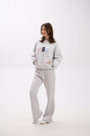 Woman wearing a gray sweatshirt and pants with 'USA' text on a white background.