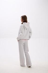 Grey sweatpants with elastic waistband, side pockets, and pink “Stay Close” embroidery on the back.