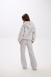 Grey sweatpants with elastic waistband, side pockets, and pink “Stay Close” embroidery on the back.