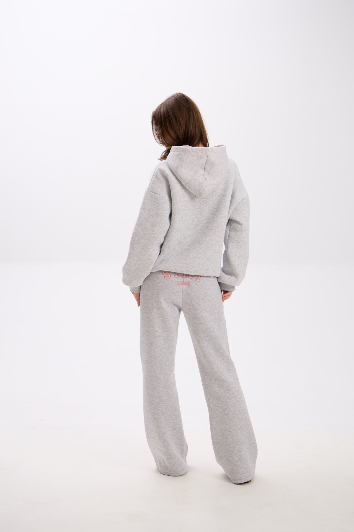Grey sweatpants with elastic waistband, side pockets, and pink “Stay Close” embroidery on the back.