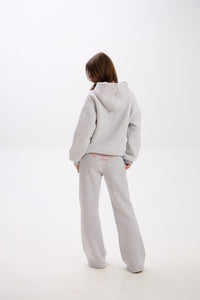 Grey sweatpants with elastic waistband, side pockets, and pink “Stay Close” embroidery on the back.