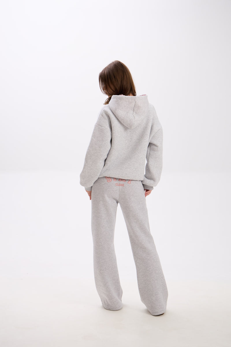 Grey sweatpants with elastic waistband, side pockets, and pink “Stay Close” embroidery on the back.