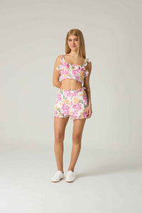 Woman wearing a floral two-piece outfit on a plain background.