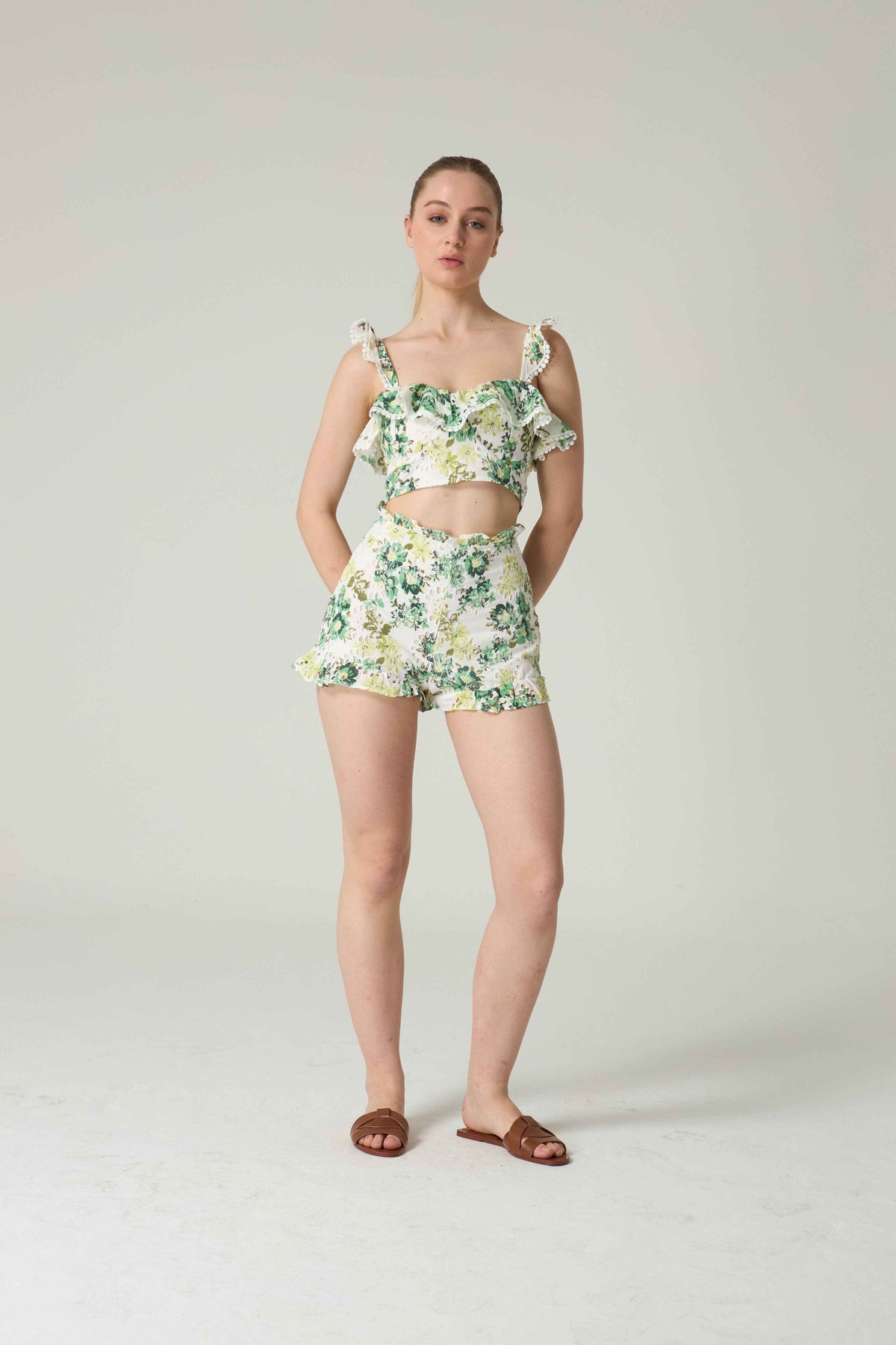 Woman wearing a floral two-piece outfit on a plain background.