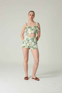 Woman wearing a floral two-piece outfit on a plain background.