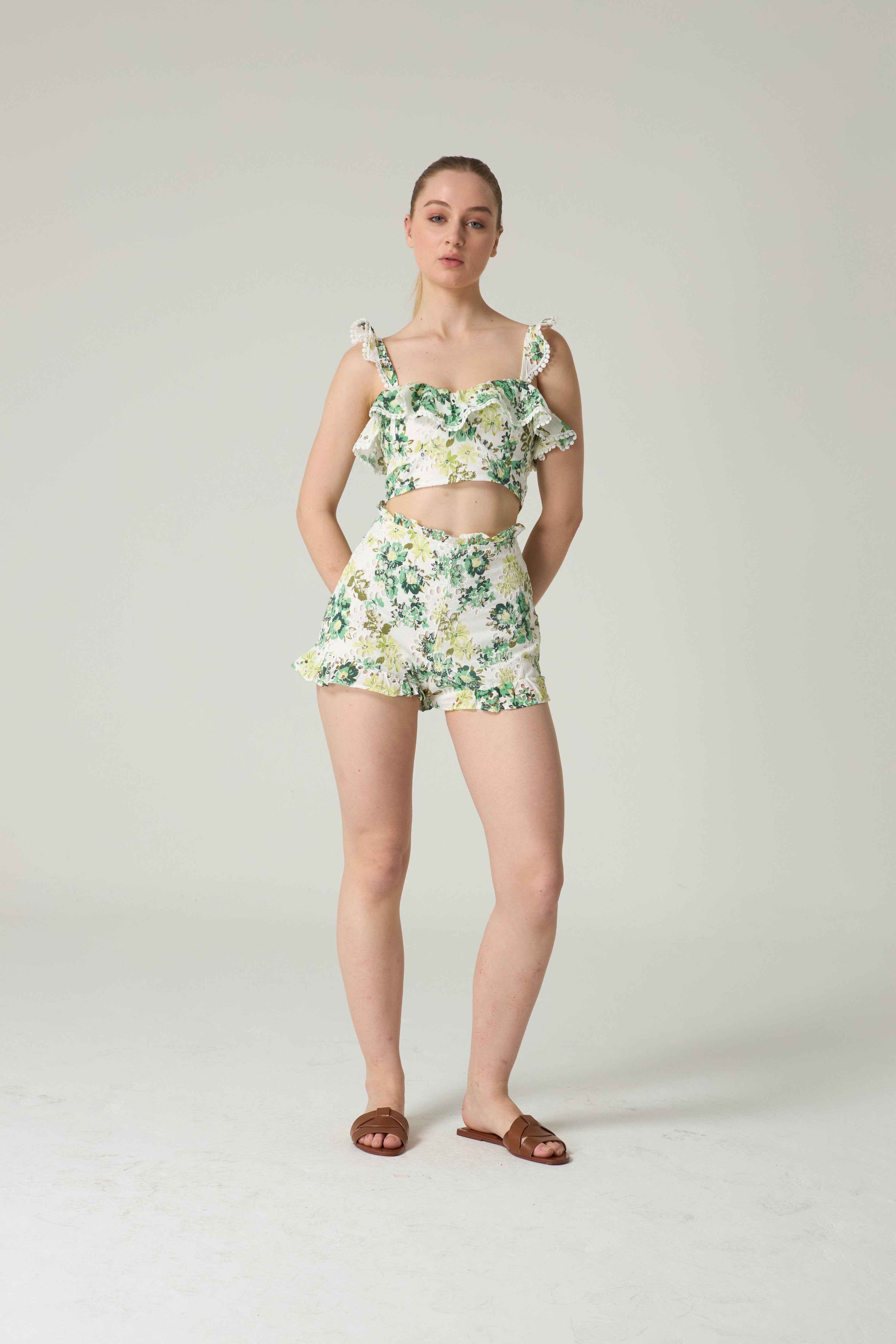 Woman wearing a floral two-piece outfit on a plain background.