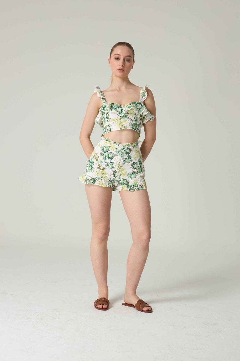 Woman wearing a floral two-piece outfit on a plain background.