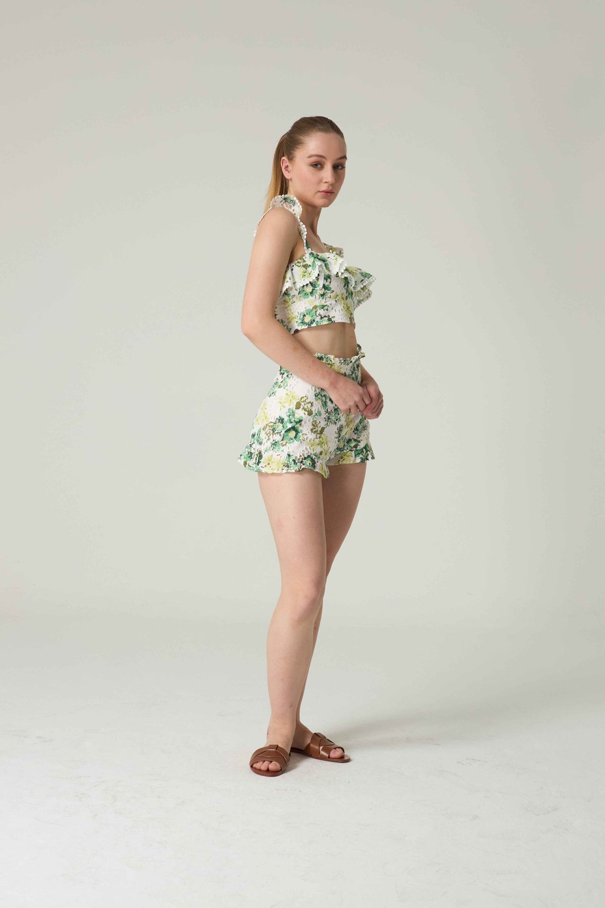 Woman wearing a floral two-piece outfit on a plain background.