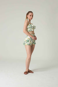 Woman wearing a floral two-piece outfit on a plain background.